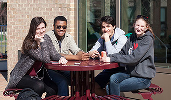 Students at a red, round picnic table
