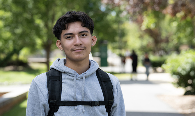 Young man in grey hoodie with black backpack