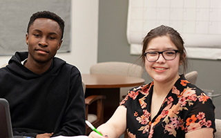 man in black hoodie and girl with floral shirt and glasss