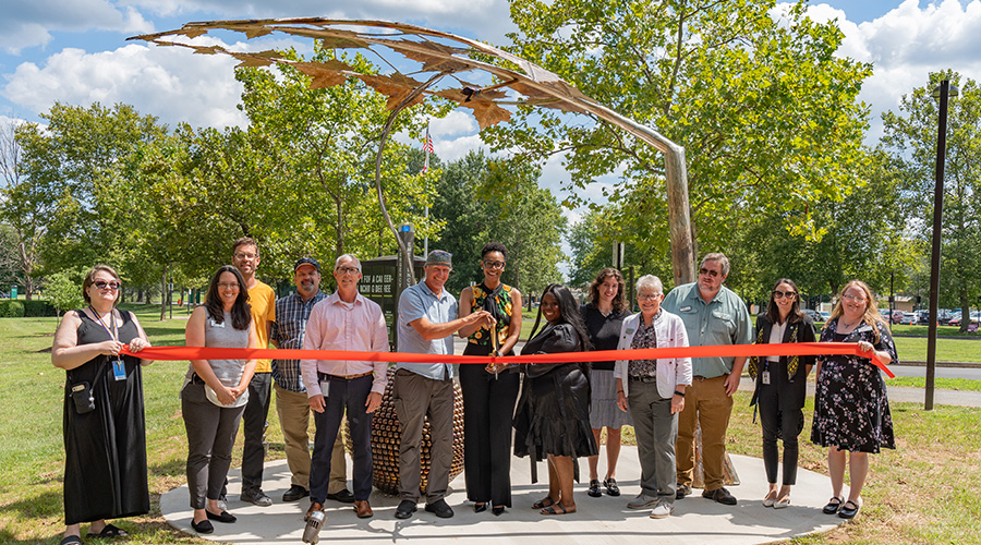 Photo caption: FCC President Dr. Annesa Payne Cheek, Artist Thomas Sterner, and Poet/FCC Alum Kiki Wilson, joined by others, cut the ribbon in front of the “Growth” sculpture on FCC’s campus.