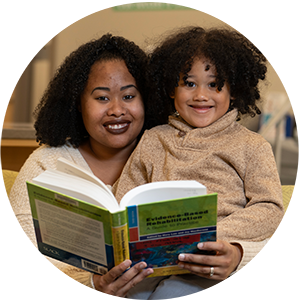 woman reading book to child on lap