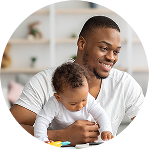 Man with child in lap looking at laptop